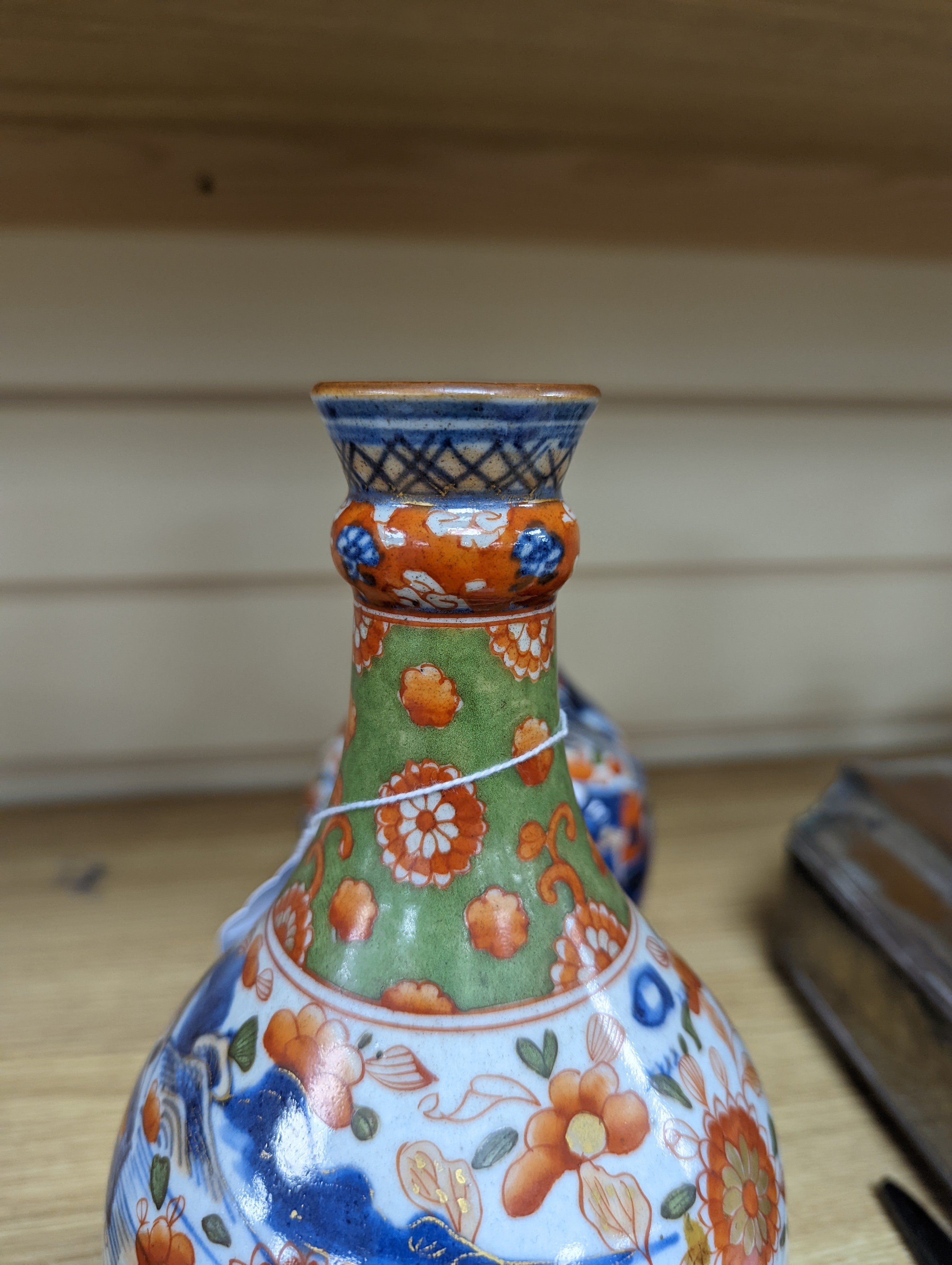 A pair of 18th century Chinese clobbered blue and white bottle vases 23cm